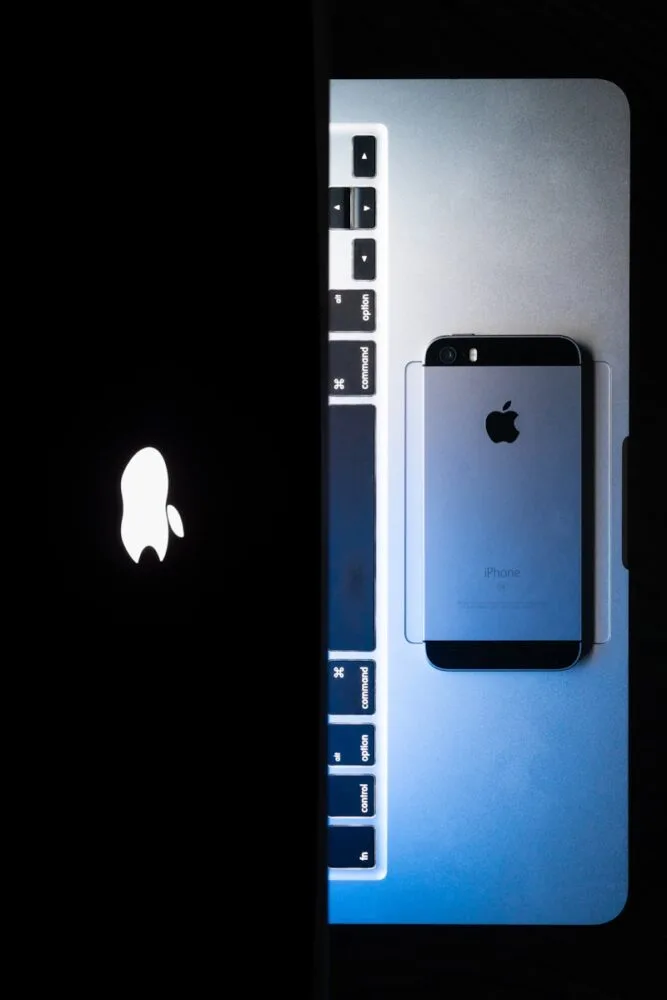 an image of an iphone next to a laptop